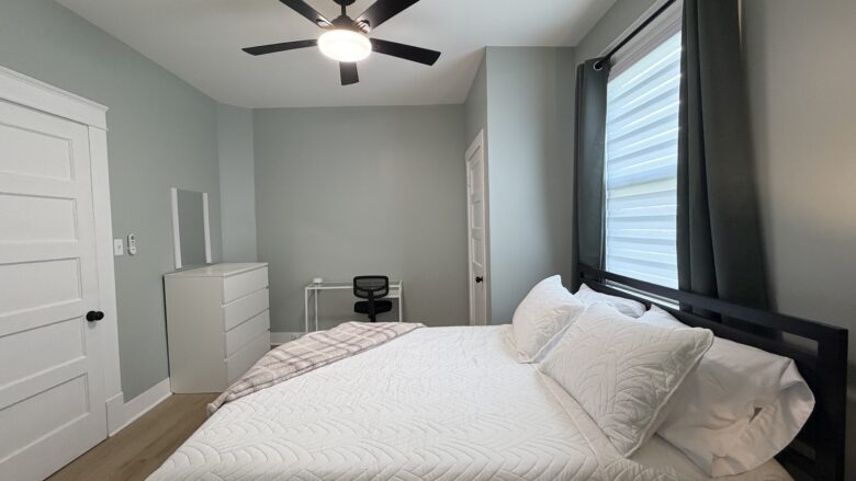 Bedroom at back of home off of the dining room - Queen bed and desk in room. Door in room leads to bathroom